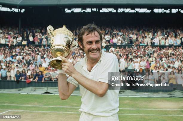 Australian tennis player John Newcombe pictured holding the Gentlemen's Singles Trophy in the air after defeating Stan Smith to win the final of the...