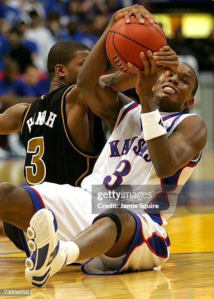 Russell Robinson of the Kansas Jayhawks and Sefhon Hannah of the Missouri Tigers battle for a loose ball during the second half of the game January...