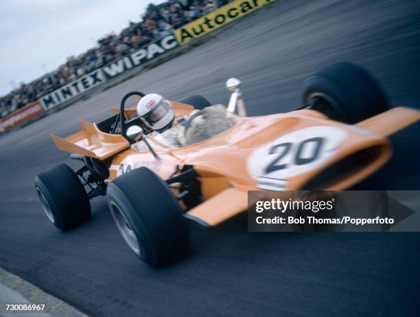 British racing driver Derek Bell drives the Bruce McLaren Motor Racing McLaren M9A Cosworth V8 in the 1969 British Grand Prix at Silverstone racing...