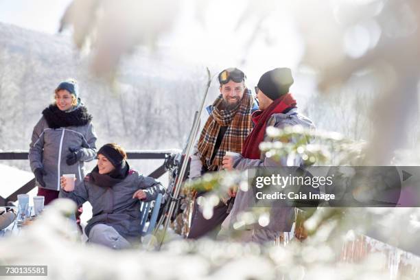 skier friends relaxing, drinking coffee and hot cocoa apres-ski - hot toddy stock pictures, royalty-free photos & images