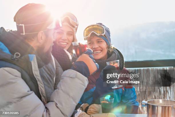 smiling skier friends drinking cocktails apres-ski - hot toddy stock pictures, royalty-free photos & images