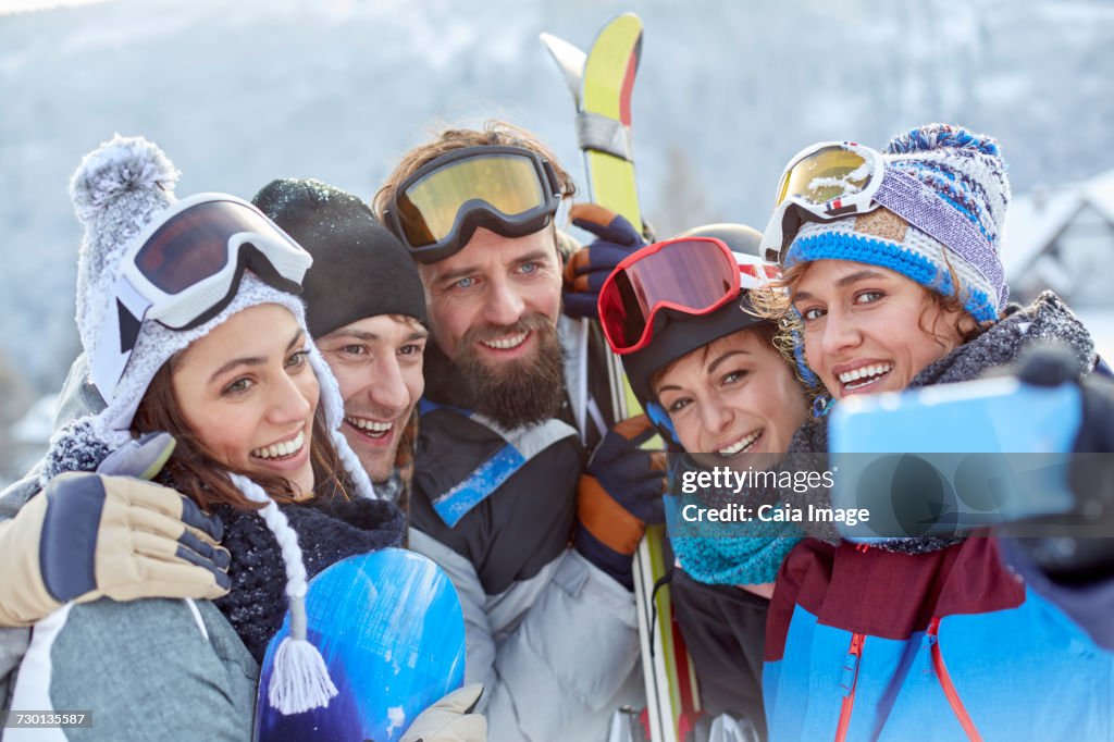 Smiling skier friends taking selfie with camera phone