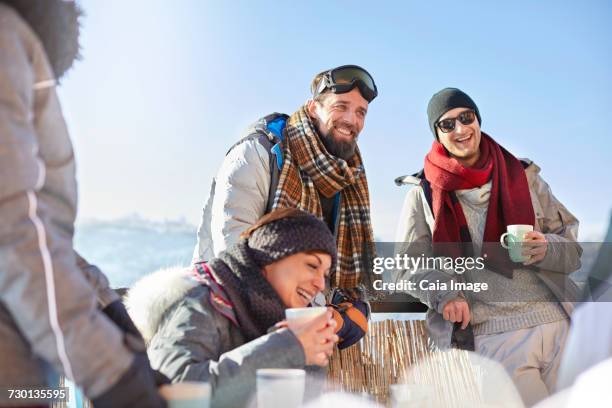 smiling skier friends drinking coffee and hot cocoa outside apres-ski - hot toddy stockfoto's en -beelden