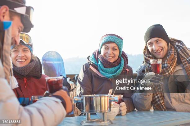 snowboarder friends drinking cocktails on sunny patio apres-ski - hot toddy stock pictures, royalty-free photos & images