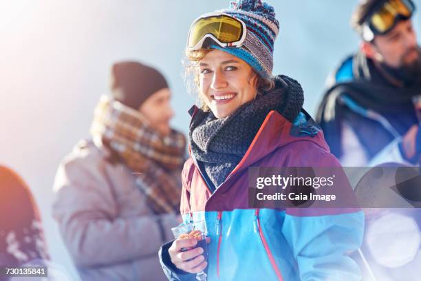 portrait smiling female skier drinking cocktail - hot toddy stockfoto's en -beelden