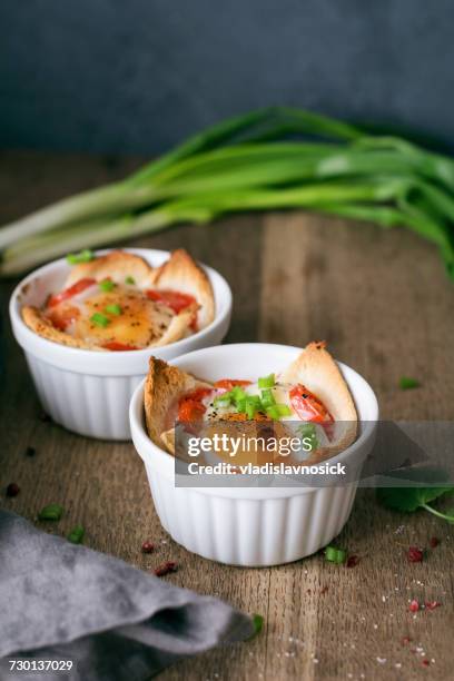 baked eggs with tomatoes, bread and scallions - ramequin photos et images de collection