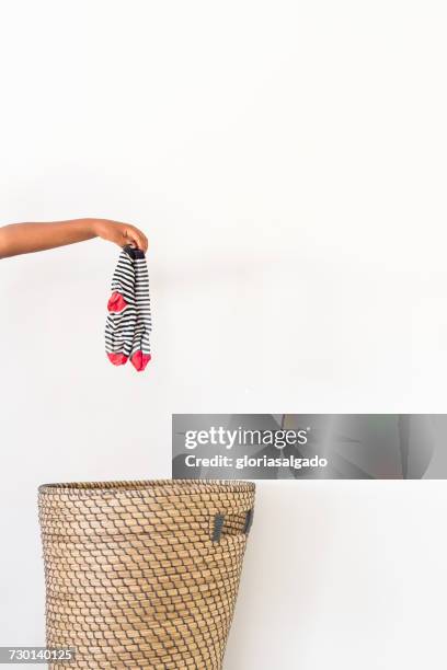 hand putting dirty socks in laundry basket - dirty sock stock pictures, royalty-free photos & images