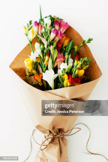 bouquet wrapped in paper - freesia flowers stock pictures, royalty-free photos & images