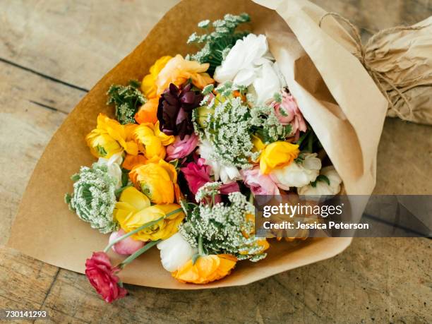 bouquet wrapped in paper - blumenbouqet stock-fotos und bilder