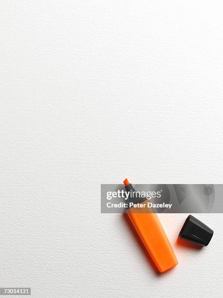 orange highlight marker with lid on side, overhead view - pens fotografías e imágenes de stock