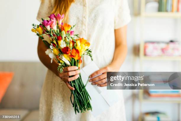 woman holding bouquet and letter - freesia stock pictures, royalty-free photos & images