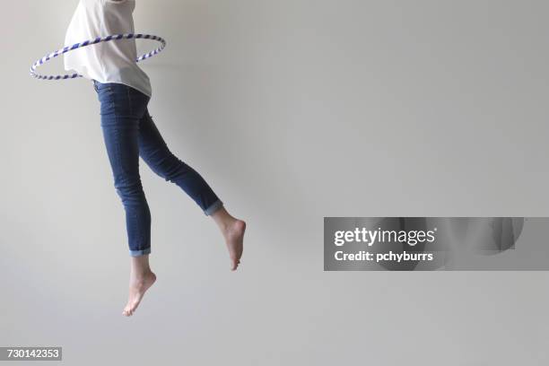woman jumping mid air with plastic hoop round her waist - pchyburrs stock pictures, royalty-free photos & images