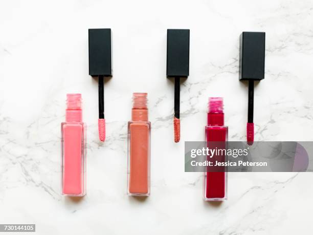 lip glosses on marble background - lipgloss stock-fotos und bilder