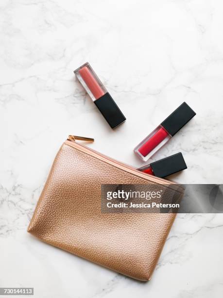 lip glosses and purse on marble background - make up bag stock pictures, royalty-free photos & images