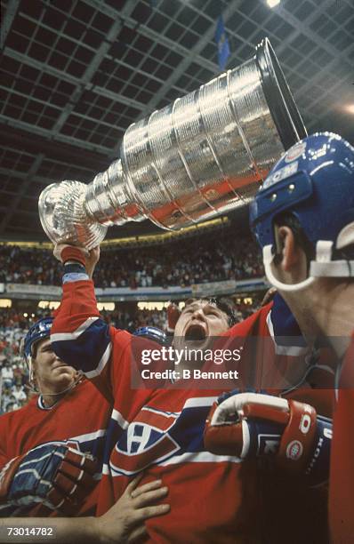 Canadian professional ice hockey player Claude Lemieux of the Montreal Canadiens lifts the Stanley Cup over his head in celebration after his team...