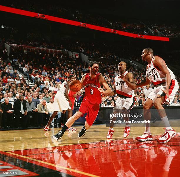 Jose Calderon of the Toronto Raptors drives to the basket against Jarrett Jack and Jamaal Magloire of the Portland Trail Blazers during a game at The...