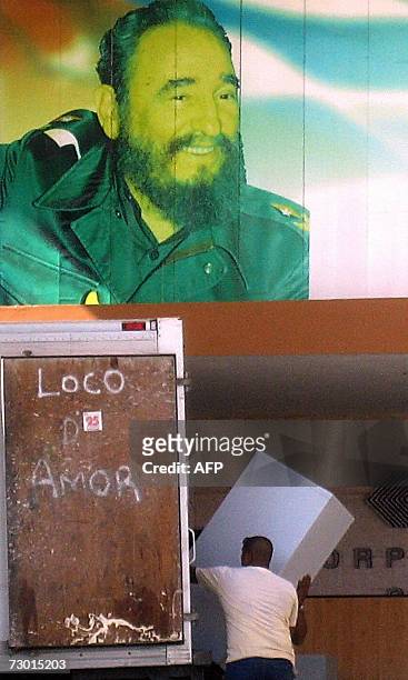 Worker unloads marchandise from a lorry in front of a bilboard depicting Cuban President Fidel Castro, 16 January, 2007 in Havana. Cuban authorities...
