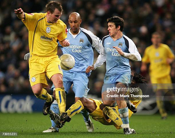 Ousmane Dabo and Joey Barton of Manchester City clash with Glen Whelan and Yoanne Folly of Sheffield Wednesday during the FA Cup sponsored by E.ON...