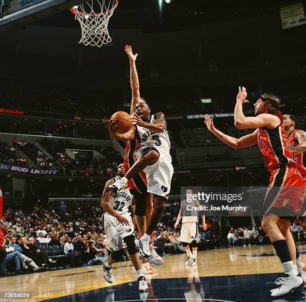 Chucky Atkins of the Memphis Grizzlies drives to the basket for a layup against Troy Murphy of the Golden State Warriors during a game at the...