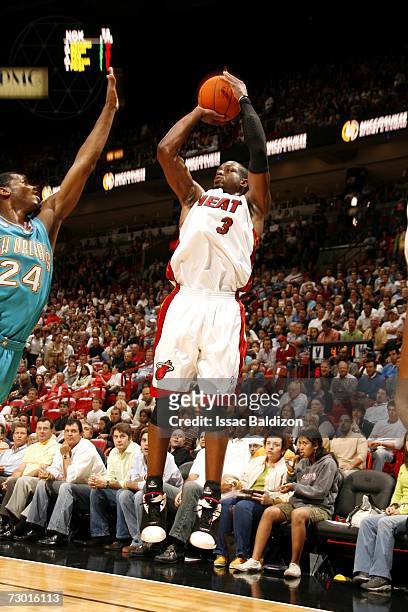 Dwyane Wade of the Miami Heat shoots over Desmond Mason of the New Orleans/Oklahoma City Hornets during the game at American Airlines Arena on...