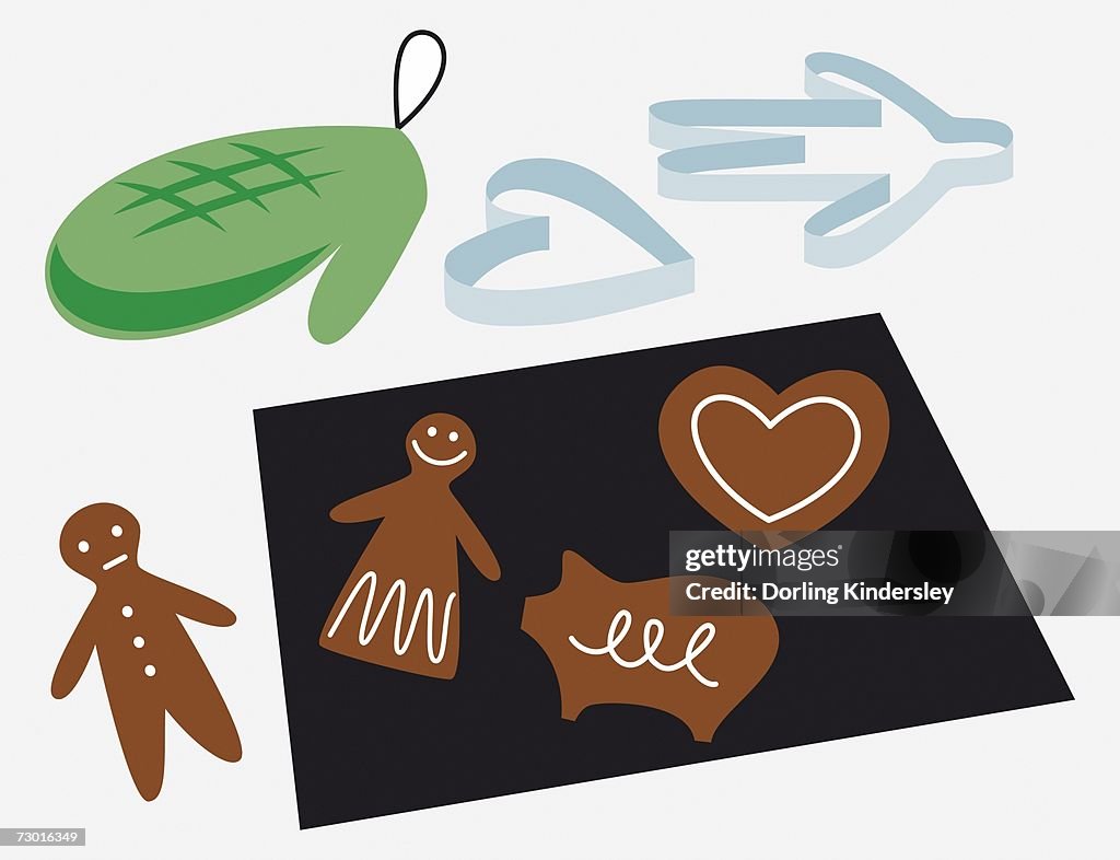 Gingerbread biscuits on baking tray, with oven gloves and shape cutter.