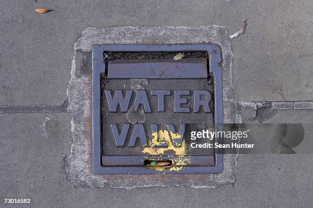 metal cover 'water valve'. - canalisation stock pictures, royalty-free photos & images