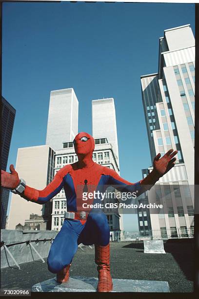 Promotional portrait of American actor Nicholas Hammond, as the costumed superhero Spider-man, as he crouches on the roof of a building near the...