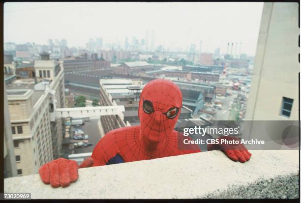 Promotional portrait of American actor Nicholas Hammond, as the costumed superhero Spider-man, as he peers over the edge of a window sill on the CBS...