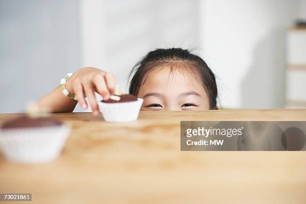 "girl (5-7) reaching cupcake on counter, high section" - kitchen bench top stock pictures, royalty-free photos & images