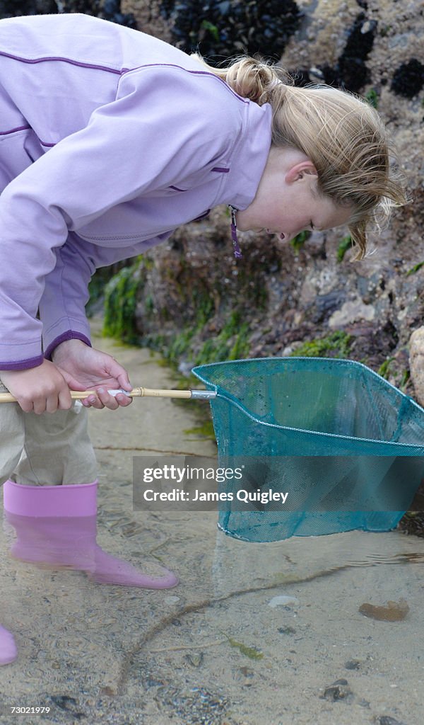 Girl (8-10) inspecting net