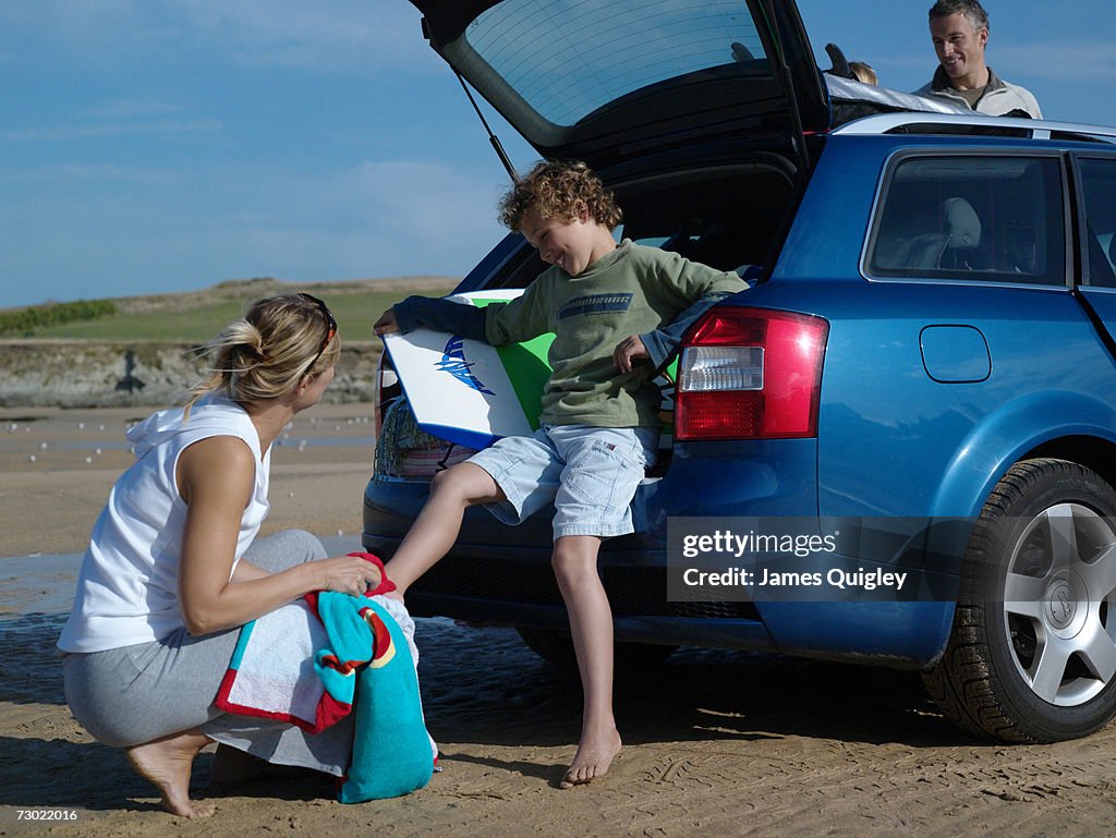 Woman drying feet of boy (7-9) at beach