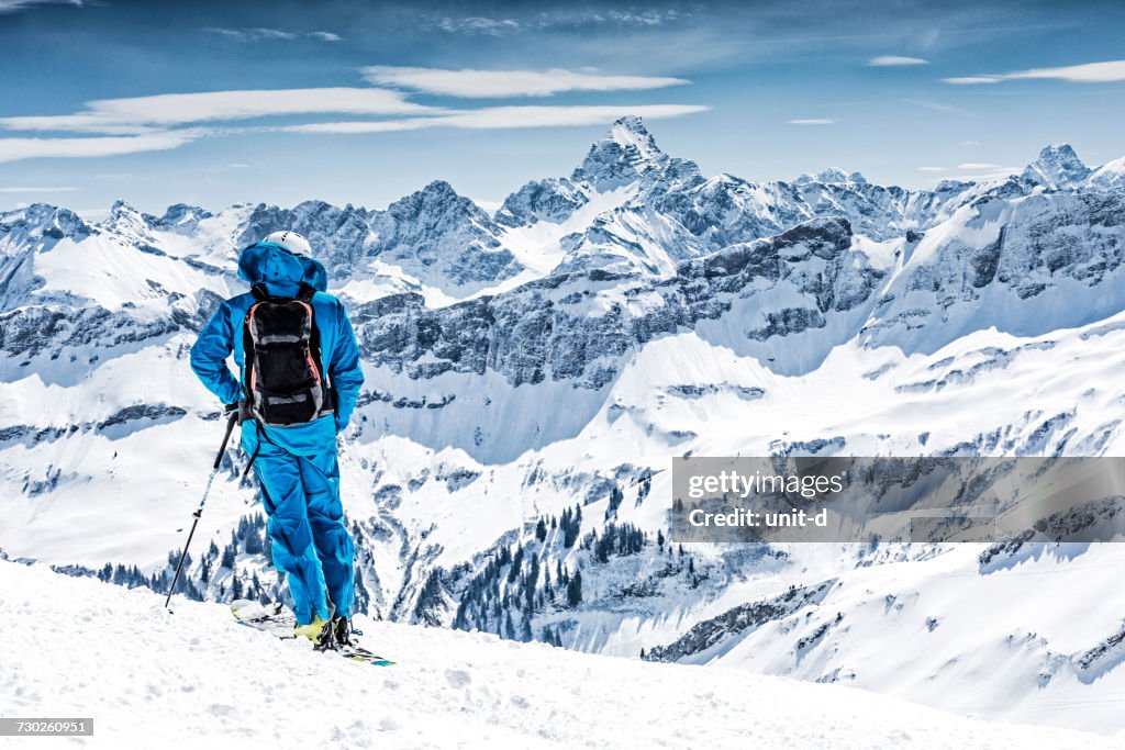 Man Standing On Snow Covered Landscape Against Sky