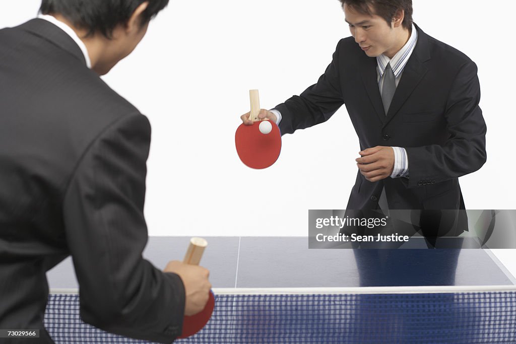 Two businessmen playing table tennis