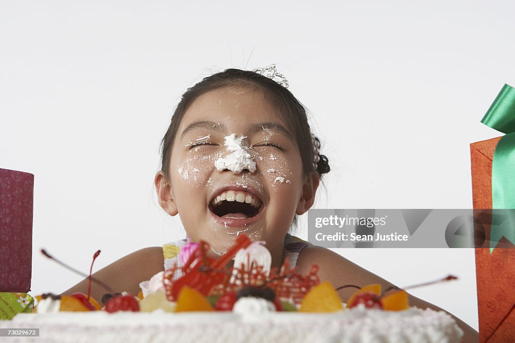 Girl (6-8) with frosting on face