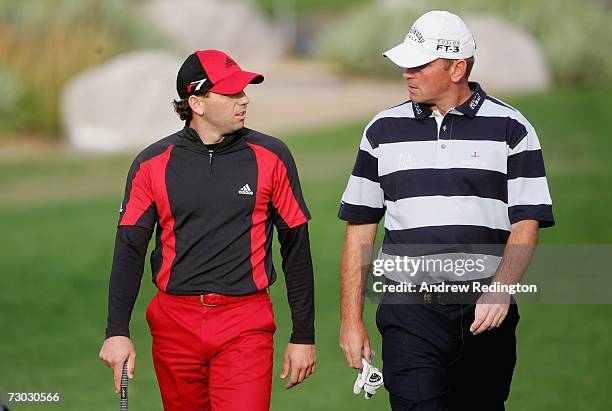 Sergio Garcia of Spain chats with Thomas Bjorn of Denmark on the 12th hole during the first round of The Abu Dhabi Golf Championship at Abu Dhabi...