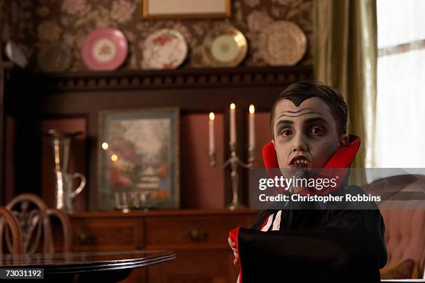boy (6-7) dressed as vampire posing in living room, portrait - vampiro fotografías e imágenes de stock