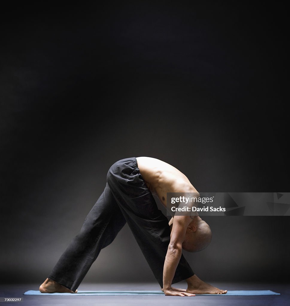 Man stretching in yoga pose, side view