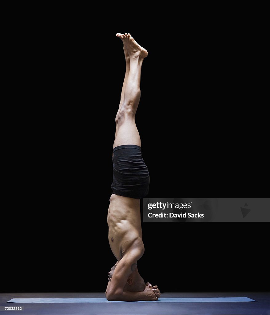 Man in yoga headstand, side view
