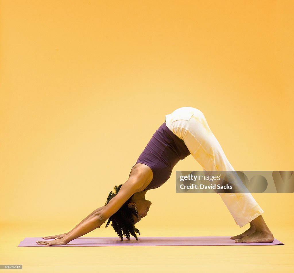 Woman in downward dog yoga stretch, side view