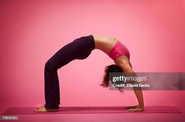 young woman in yoga back bend, side view - bending over backwards stock pictures, royalty-free photos & images