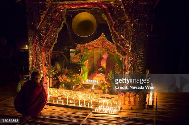 tibetan buddhist monk praying on floating pagoda at night, sin nina village, chindwin river, myanmar (burma) - chindwin stock pictures, royalty-free photos & images
