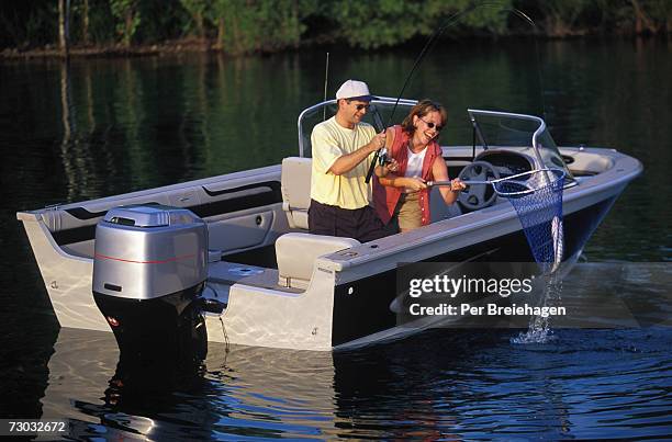 couple fishing from motorboat - branson missouri stock pictures, royalty-free photos & images