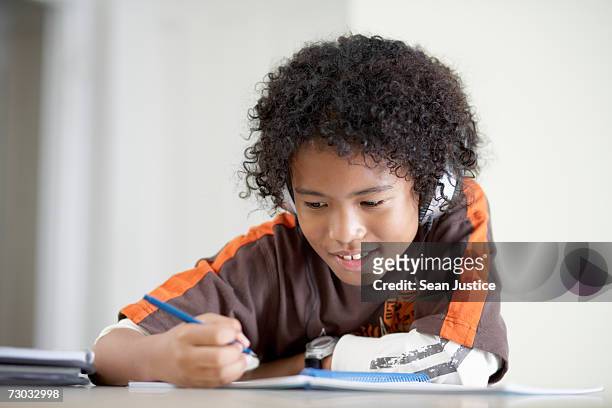 boy (10-11) doing homework indoors - writing music stock pictures, royalty-free photos & images