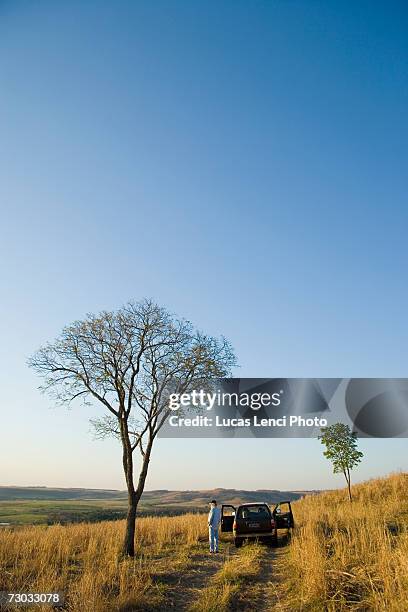 man standing outside car in remote area - ancine and car stock pictures, royalty-free photos & images