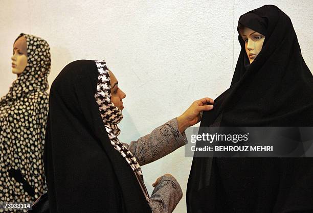 An Iranian woman checks mannequins in a traditional Islamic dress during a fashion show in Tehran, 18 January 2007. The two-day event was organized...