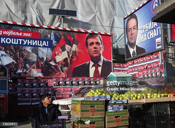 Street vendor sells fruit in front of election posters for Vojislav Kostunica, the Serbian Prime Minister and leader of the Democratic Party of...