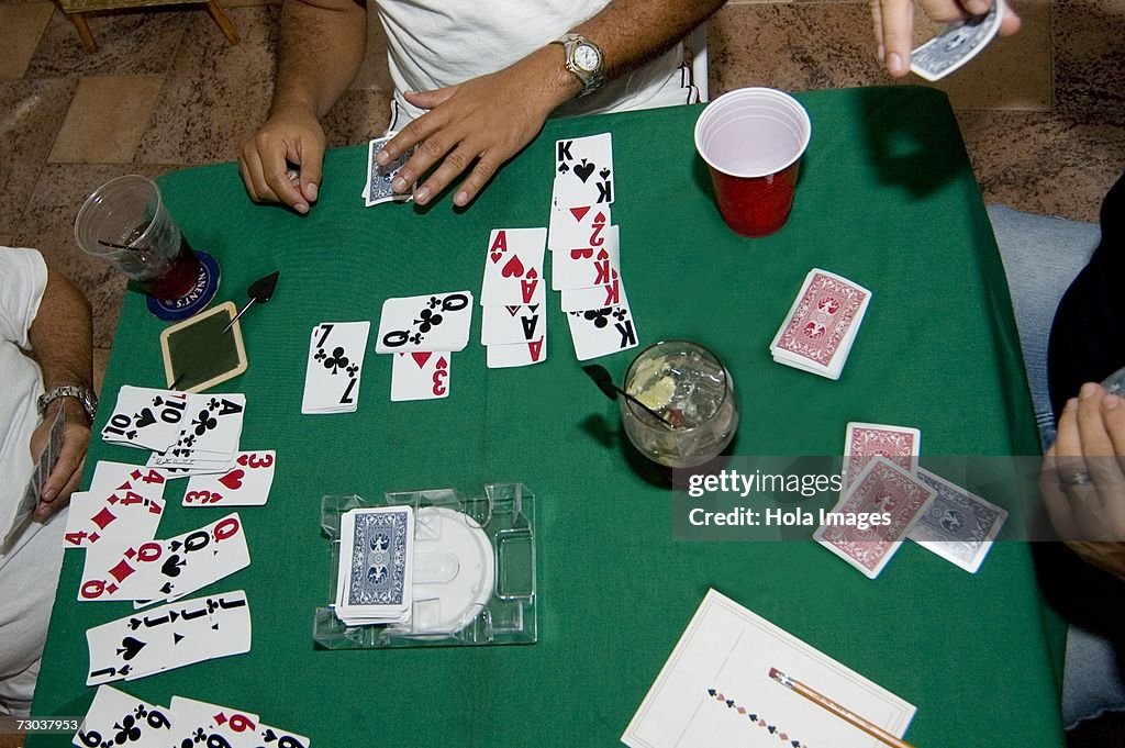 High angle view of three people playing cards