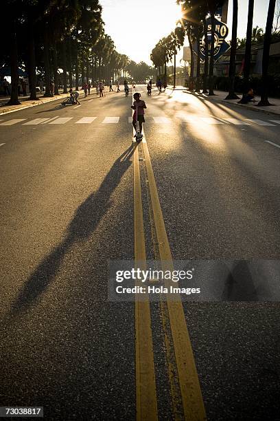 silhouette of a girl riding a push scooter, malecon, santo domingo, dominican republic - malecon stock-fotos und bilder
