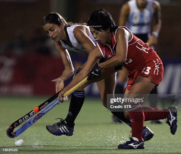 Argentina's Mariana Gonzalez Oliva and Japan's Sachimi Iwao fight for the ball during their Champions Trophy field hockey match in Quilmes, Buenos...