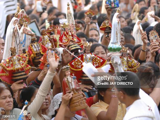 Priest blesses devotees and the religious icons as they attend a mass at the Basilica Del Santo Nino in Cebu city, 19 January 2007. The mass is part...